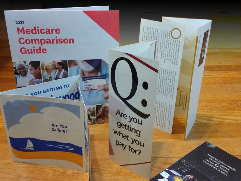 Several brochures, standing and laying on table. 