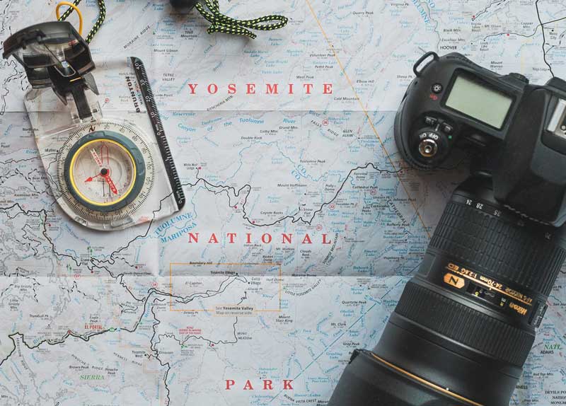 Printed map of Yosemite National park with a compass laying on top.