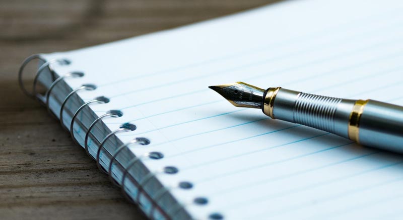 Open spiral notebook laying on table.